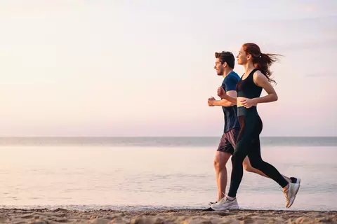 Man en vrouw lopen op het strand