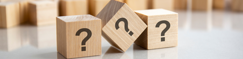 Afbeelding van 3 houten blokken met vraagtekens op